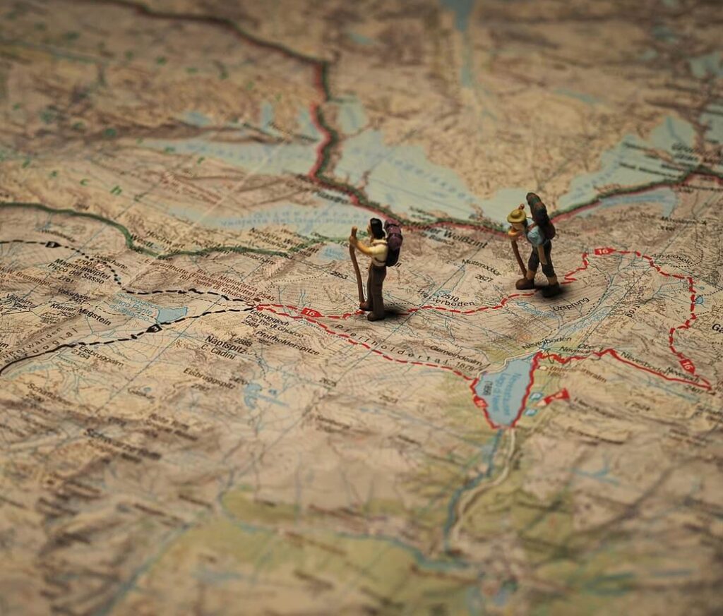 Miniature hikers on a map symbolizing the Ego's intentional path and the RAS highlighting opportunities for living with purpose.