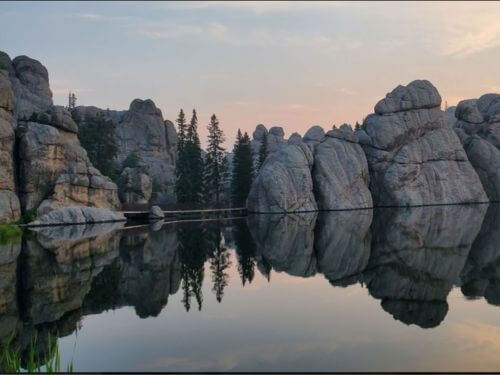 Granite spires reflecting in the water on a foggy morning in the Black Hills, symbolizing the beginning of the path to personal transformation and clarity for the Kimchi Burrito Manifesto.